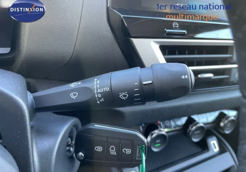 Gros plan sur la commande d’essuie-glace et la clé de contact dans l’habitacle d’une Citroën C4 hybride bleu Eclipse métal.