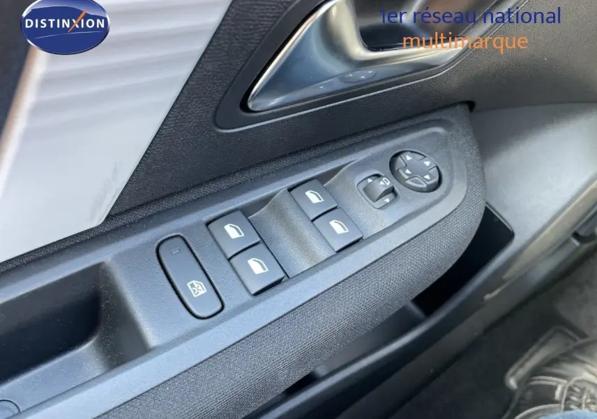 Gros plan sur les commandes des vitres et rétroviseurs côté conducteur d'une Citroën C4 hybride 2026, intérieur noir.