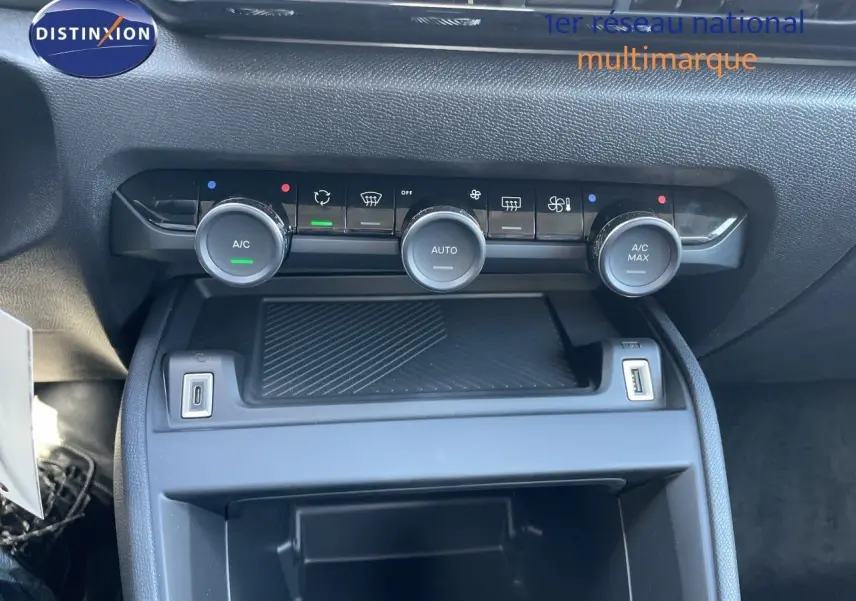 Gros plan sur la console centrale de la Citroën C4 Hybrid 2026, montrant les commandes de climatisation et ports USB.
