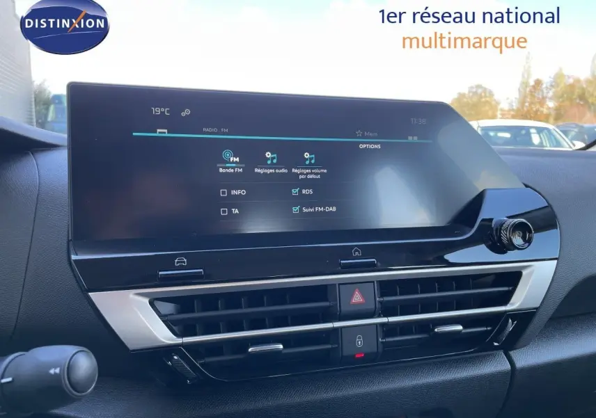 Intérieur du tableau de bord de la Citroën C4 Hybrid 2026, écran tactile et commandes climatisation visibles.