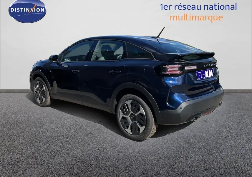 Vue 3/4 arrière droite d'une Citroën C4 Hybrid 145ch bleu Eclipse Métal avec jantes spécifiques et toit noir.