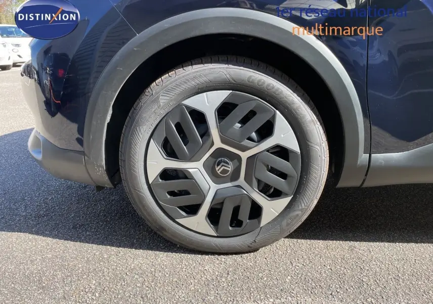 Gros plan sur la roue avant droite d'une Citroën C4 bleu Eclipse Metal avec jante au design moderne.
