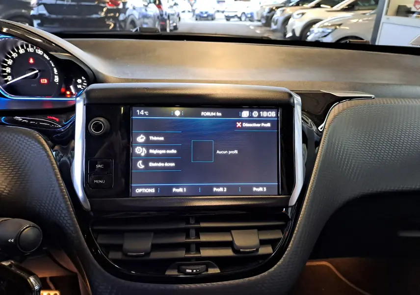 Vue rapprochée du tableau de bord noir du Peugeot 2008 gris, mettant en valeur l'écran tactile central allumé.