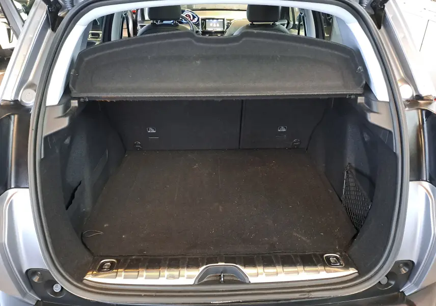 Coffre ouvert vu de l'arrière d'un Peugeot 2008 gris 2019, montrant un espace de chargement propre et une tablette cache-bagages.