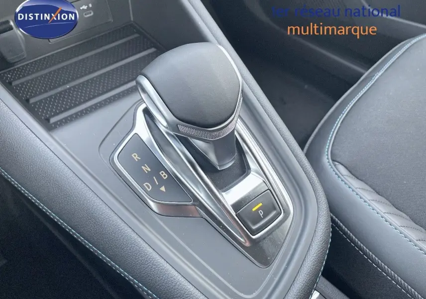 Le levier de vitesses automatique noir avec surpiqûres bleues de la Renault Symbioz 2024 en gros plan intérieur.