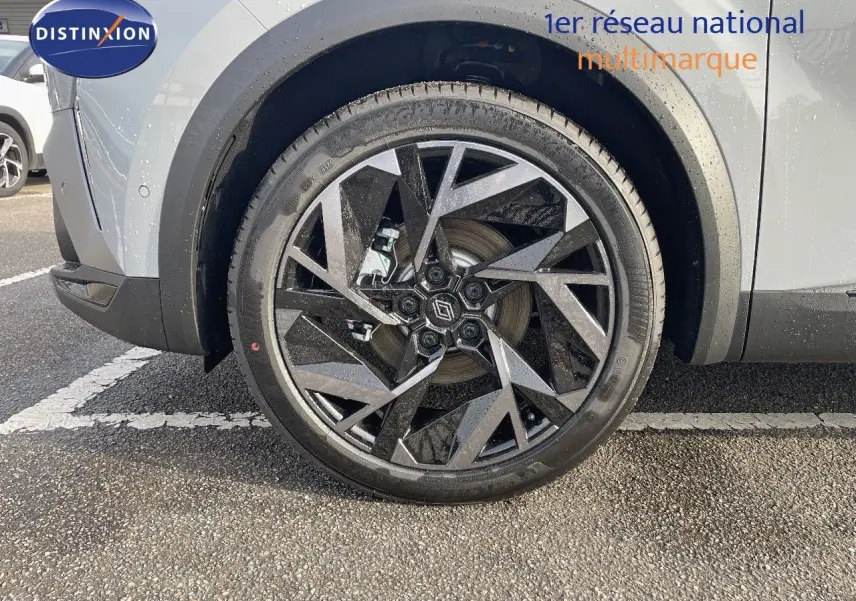 Gros plan sur la roue avant gauche du Renault Symbioz gris Rafale, mettant en valeur la jante noire et argentée au design géométrique.