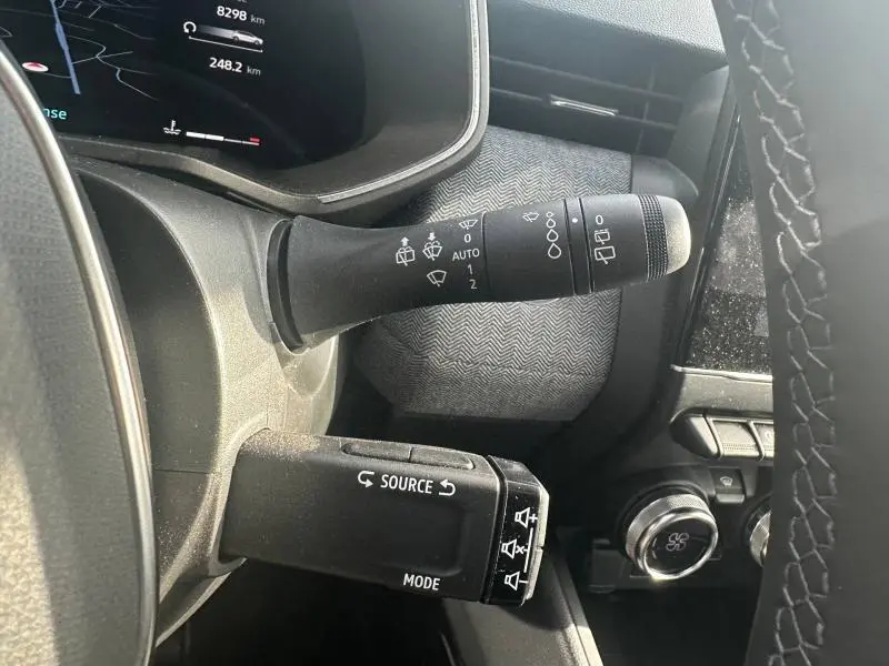 Gros plan sur les commandes de volant de la Renault Clio 2025, montrant les leviers de clignotants et essuie-glaces.