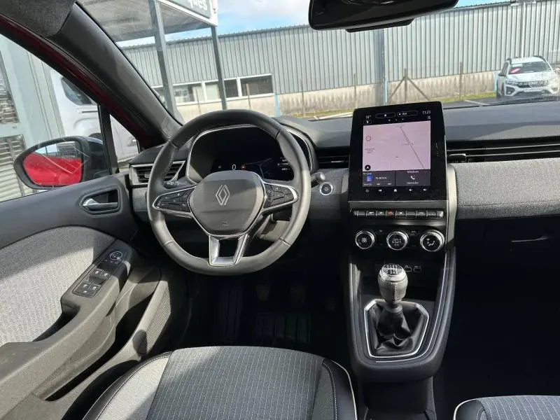 Vue intérieure avant de la Renault Clio 1.0 TCe 90ch Techno 2025 avec volant, écran tactile et levier de vitesse manuel.