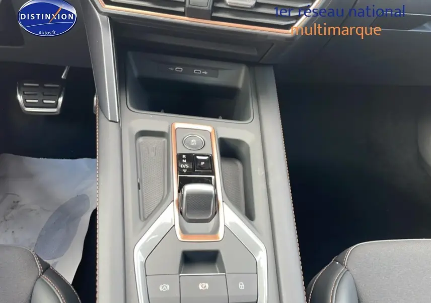 Vue intérieure centrée sur la console centrale du CUPRA Formentor gris magnétique avec levier de vitesses automatique et finitions cuivrées.