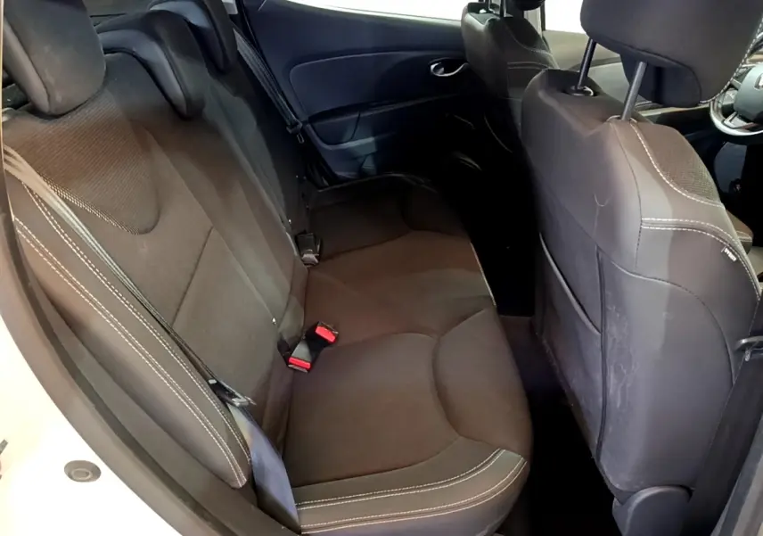 Vue intérieure côté gauche montrant la banquette arrière noire avec surpiqûres blanches d'une Renault Clio blanche 2016.
