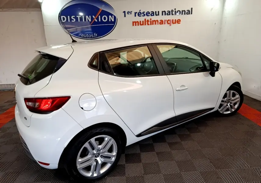 Vue 3/4 arrière droite d'une Renault Clio Zen Energy dCi 75 blanche, avec jantes alliage et rétroviseurs noirs.
