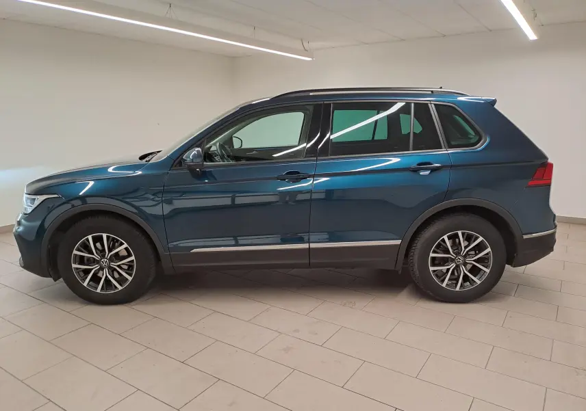 Vue de profil côté gauche d'un Volkswagen Tiguan 2023 bleu Nightshade avec jantes 17'' Tulsa et crochet d'attelage escamotable.