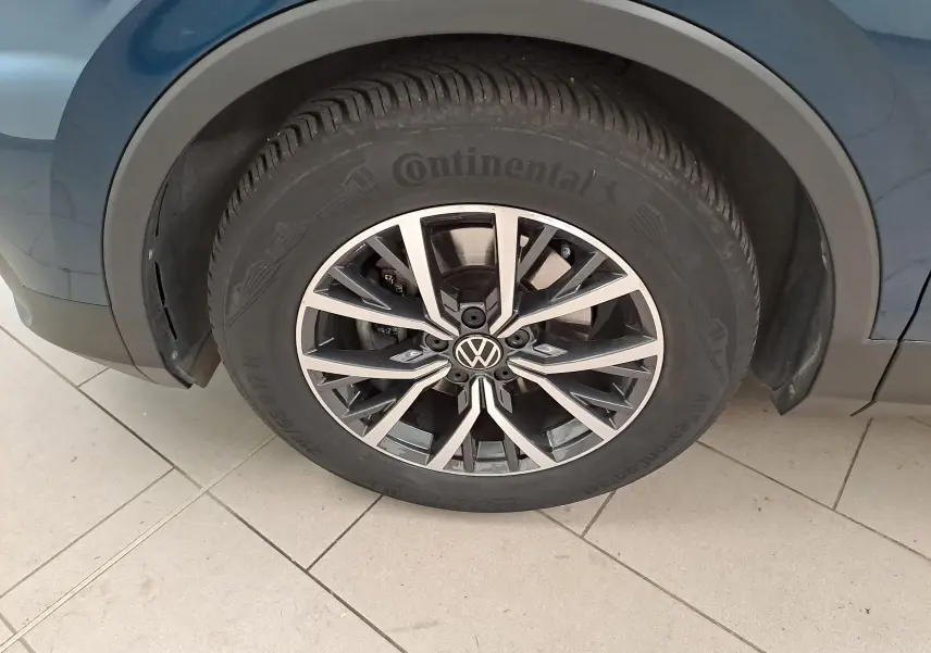 Gros plan sur la roue avant gauche du Volkswagen Tiguan 2023 en Nightshade Blue avec jante 17'' Tulsa.