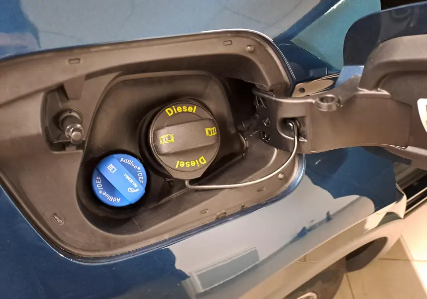 Gros plan sur la trappe à carburant d’un Volkswagen Tiguan 2023 bleu Nightshade avec bouchons Diesel et AdBlue visibles.