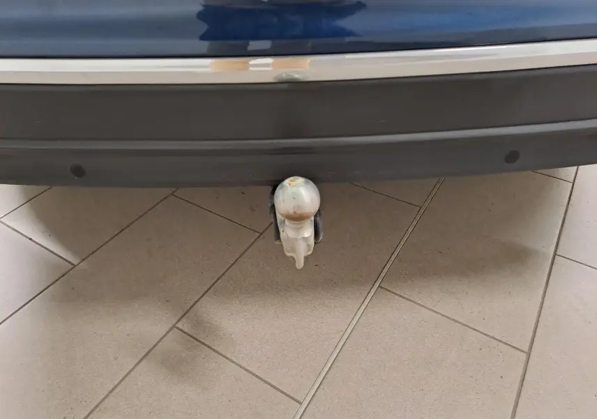Gros plan sur le crochet d'attelage escamotable sous le pare-chocs arrière bleu Nightshade du Volkswagen Tiguan 2023.