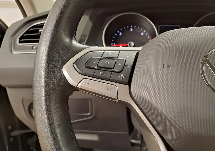 Vue rapprochée du volant multifonction noir du Volkswagen Tiguan 2023 avec commandes de régulateur de vitesse.