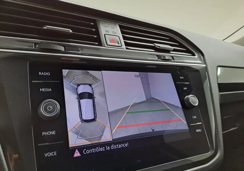 Vue intérieure sur l’écran multimédia du Volkswagen Tiguan 2023 montrant la caméra de recul et l’aide au stationnement.