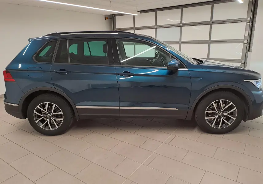 Vue de profil côté gauche du Volkswagen Tiguan 2023 en bleu Nightshade avec jantes 17'' Tulsa et crochet d'attelage escamotable.