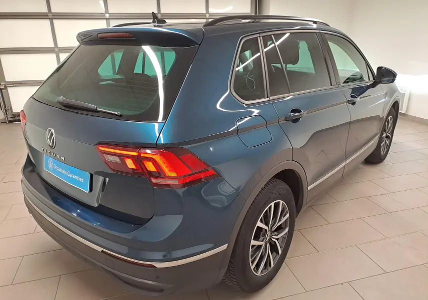Vue 3/4 arrière droite du Volkswagen Tiguan 2023 bleu Nightshade avec jantes 17'' Tulsa et crochet d'attelage escamotable.