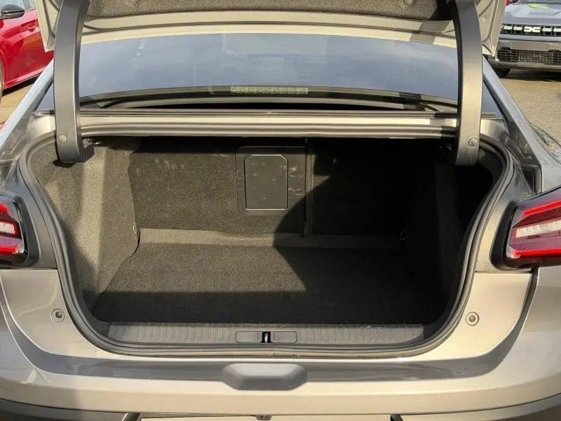 Coffre ouvert vu de l'arrière d'une Citroën C4 X 2025 gris Mercury, montrant un espace de chargement vide et propre.