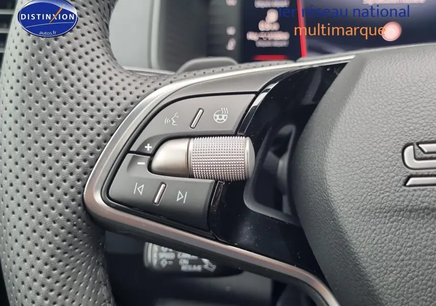 Gros plan sur les commandes gauche du volant cuir perforé du Skoda Karoq noir 2025, avec molette argentée.