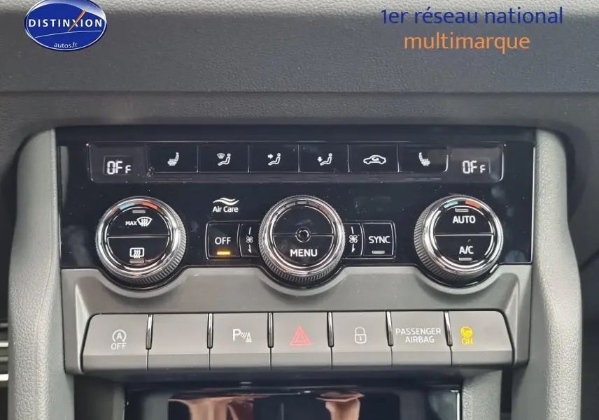 Gros plan sur la console centrale du Skoda Karoq noir 2025, mettant en valeur les commandes de climatisation et boutons fonctionnels.