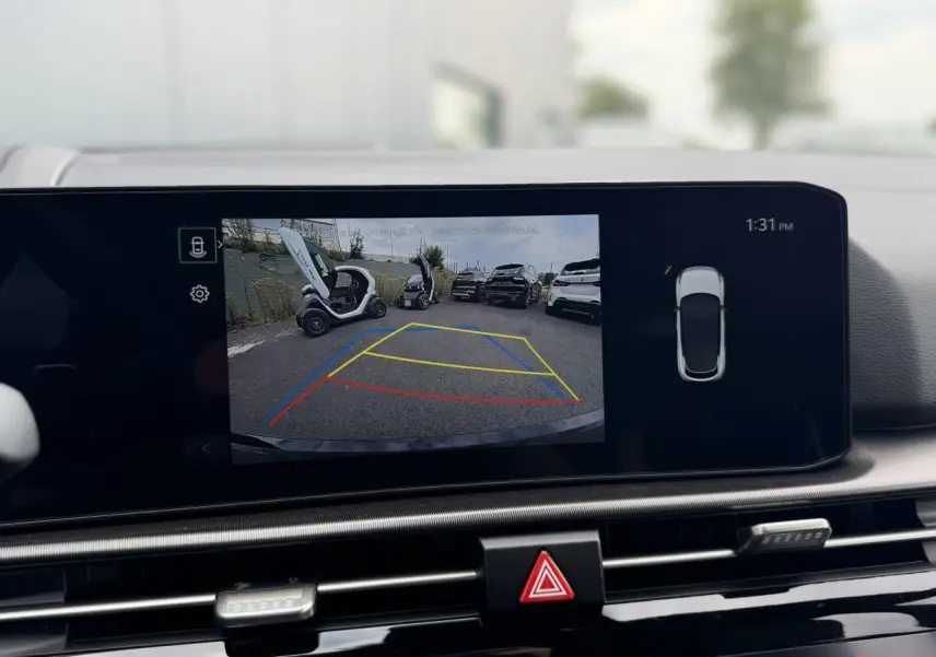Écran tactile intérieur montrant la caméra de recul du Kia Sportage gris lunaire en stationnement.