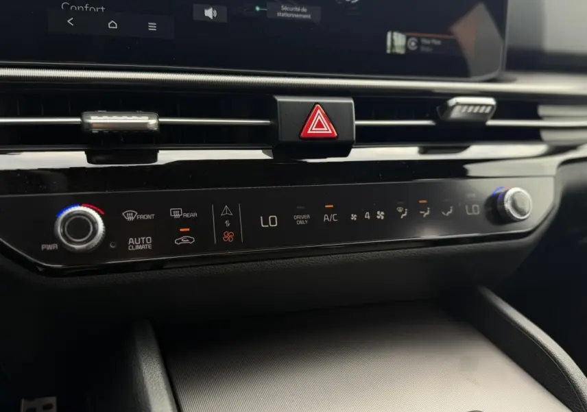 Détail de la console centrale noire brillante du Kia Sportage 2026, montrant les commandes tactiles de climatisation automatique.
