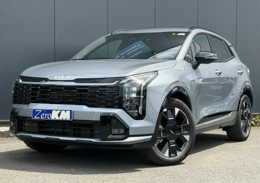 KIA SPORTAGE gris lunaire en 3/4 avant droit avec calandre noire et jantes alliage noires distinctives.