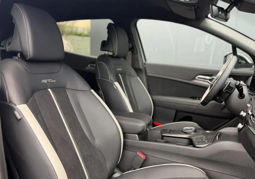 Vue intérieure côté droit du Kia Sportage 2026 GT-line avec sellerie bi-ton noir et gris et volant cuir.