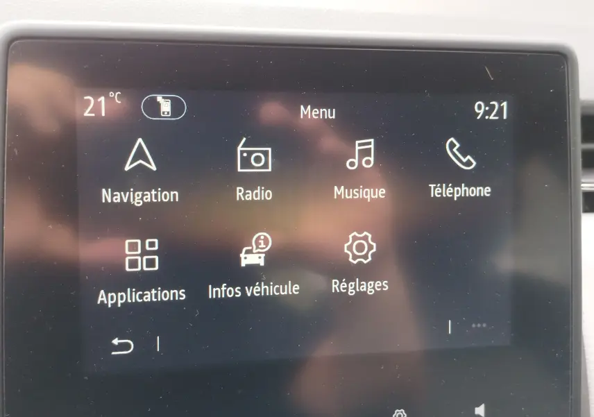 Écran tactile central de la Renault Clio 2023 affichant le menu principal avec navigation, radio, musique et téléphone.
