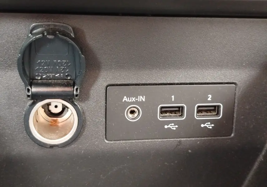 Détail intérieur montrant la prise 12V, une entrée Aux-IN et deux ports USB sur une Renault Clio blanche Glacier 2023.