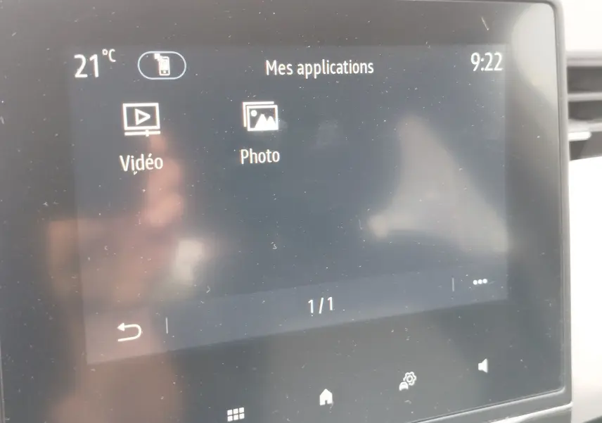 Écran tactile intérieur de la Renault Clio 2023 affichant les applications Vidéo et Photo, avec une interface sombre.