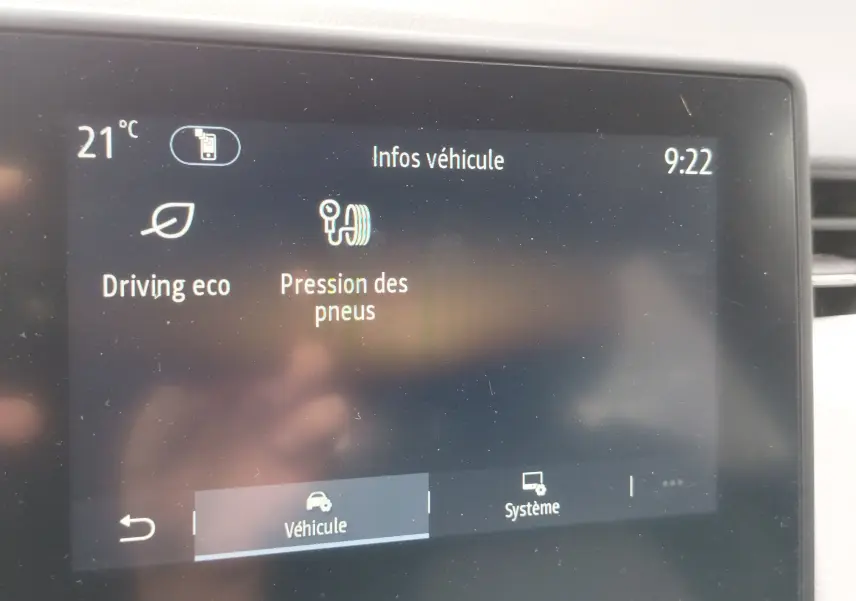 Écran tactile intérieur de la Renault Clio blanc glacier 2023 affichant les infos véhicule et pression des pneus.