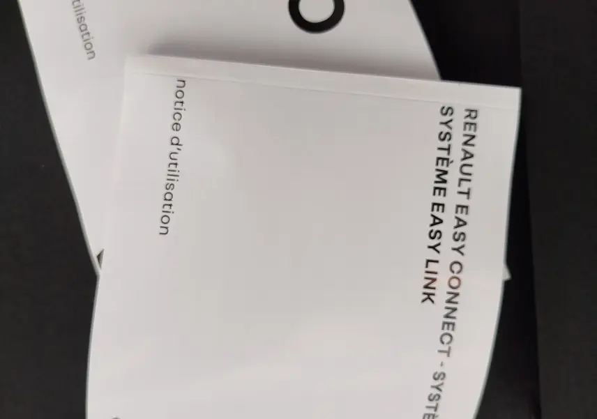 Image ne montrant pas de véhicule, mais deux notices d'utilisation blanches pour Renault Clio et système Easy Link.