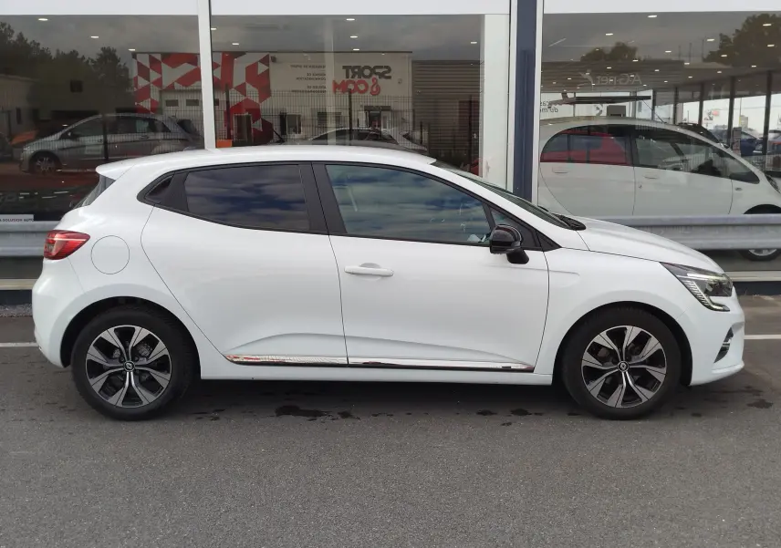 Profil droit d'une Renault Clio 1.0 SCe 65ch Evolution blanche Glacier avec jantes alliage et vitres teintées.