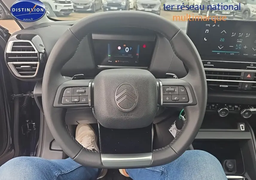Vue intérieure centrée sur le volant Citroën C4 1.2 hybride 136 plus avec tableau de bord et écran tactile visible.