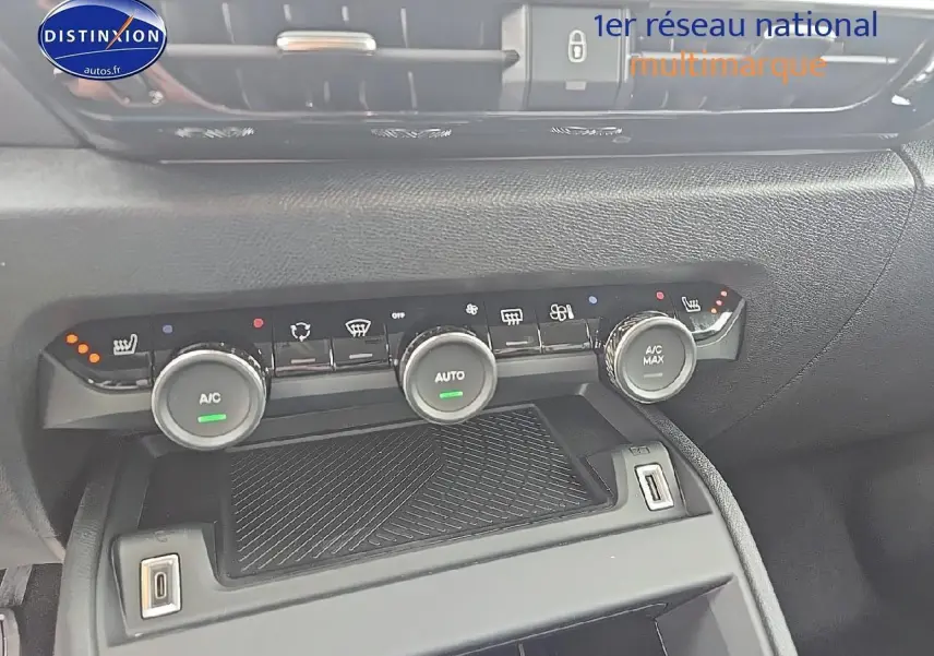 Vue rapprochée de la console centrale de la Citroën C4 bleu eclipse, montrant les commandes de climatisation et prises USB.