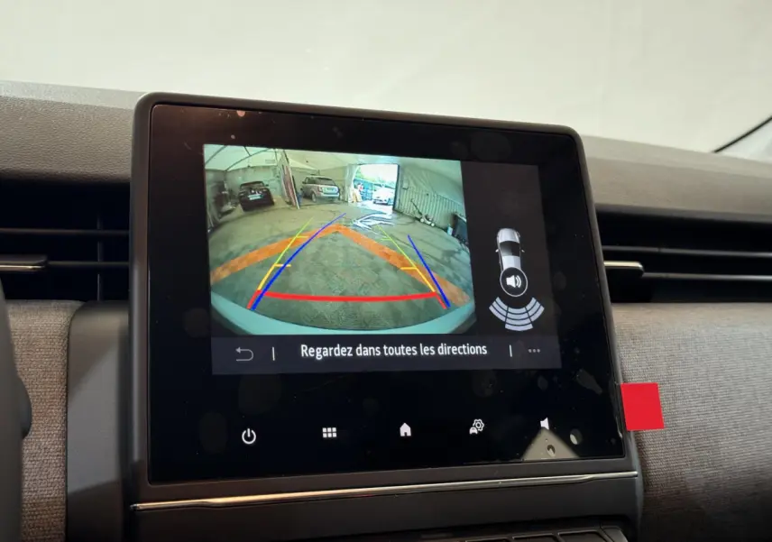 Écran tactile central de la Renault Clio gris clair montrant la caméra de recul avec guidage coloré.