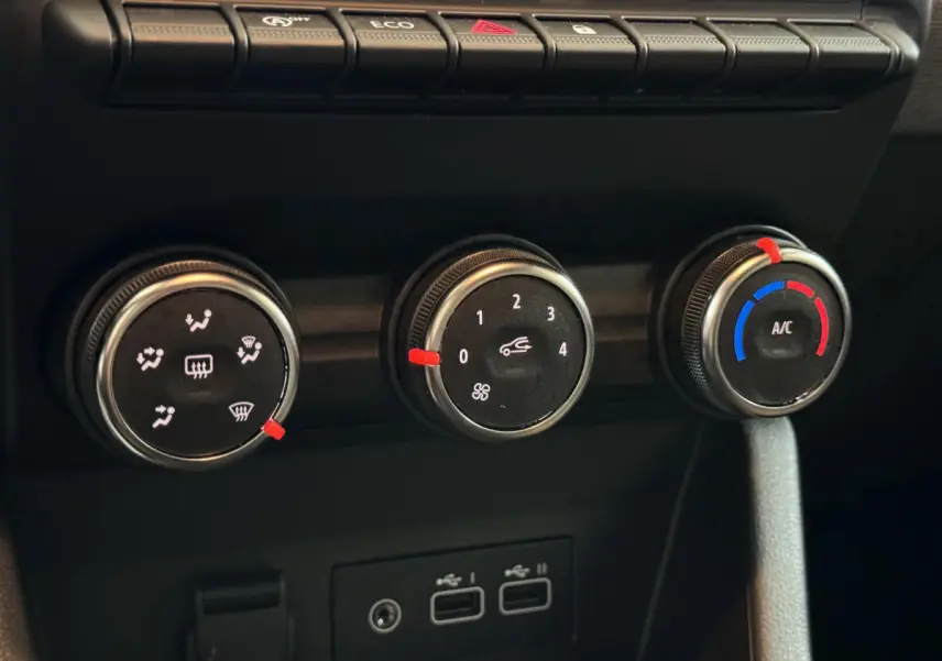 Gros plan sur les commandes de climatisation et les ports USB du tableau de bord noir de la Renault Clio gris clair Evolution Blue dCi 100 2025.