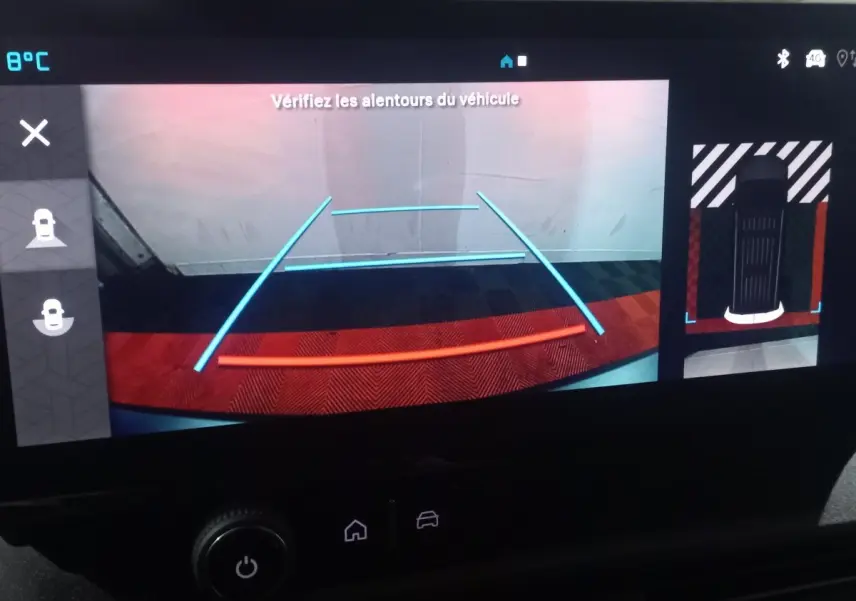 Vue de l'écran de caméra de recul du Citroën Berlingo blanc, affichant les lignes de guidage colorées et la zone arrière du véhicule.