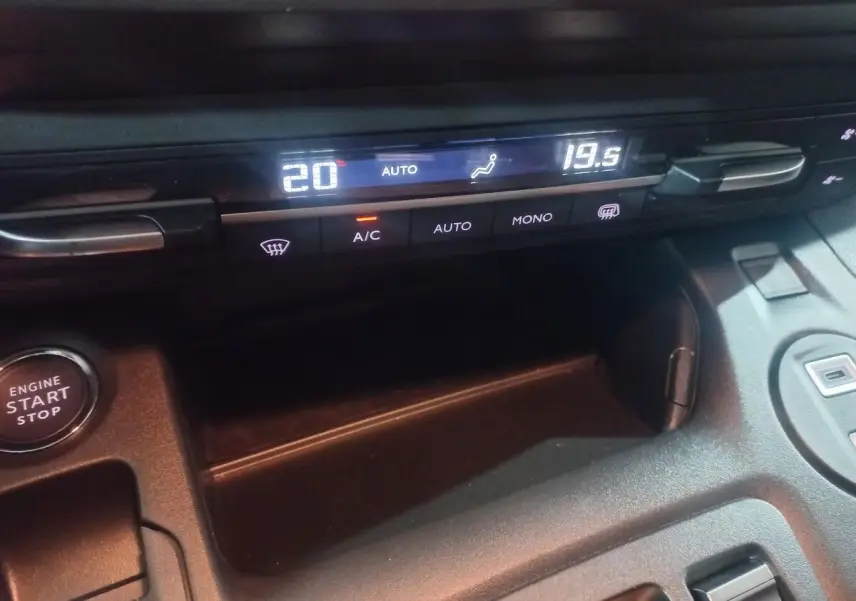 Gros plan sur la console centrale noire du Citroën Berlingo XL 2025, affichage digital de la climatisation et bouton start/stop.