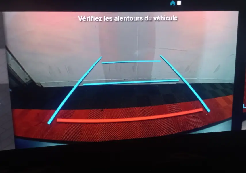 Vue caméra de recul du Citroën Berlingo blanc XL, affichant les lignes de guidage bleues et rouges au sol.