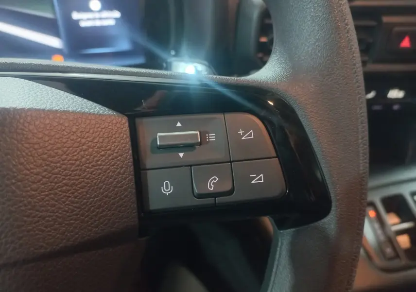 Gros plan sur les commandes du volant à droite du Citroën Berlingo blanc 2025, avec boutons de volume et appel.