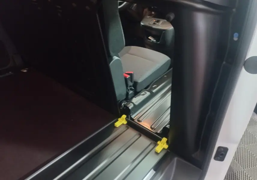 Vue intérieure côté droit du Citroën Berlingo XL blanc, montrant l'entrée et le siège avant gris.