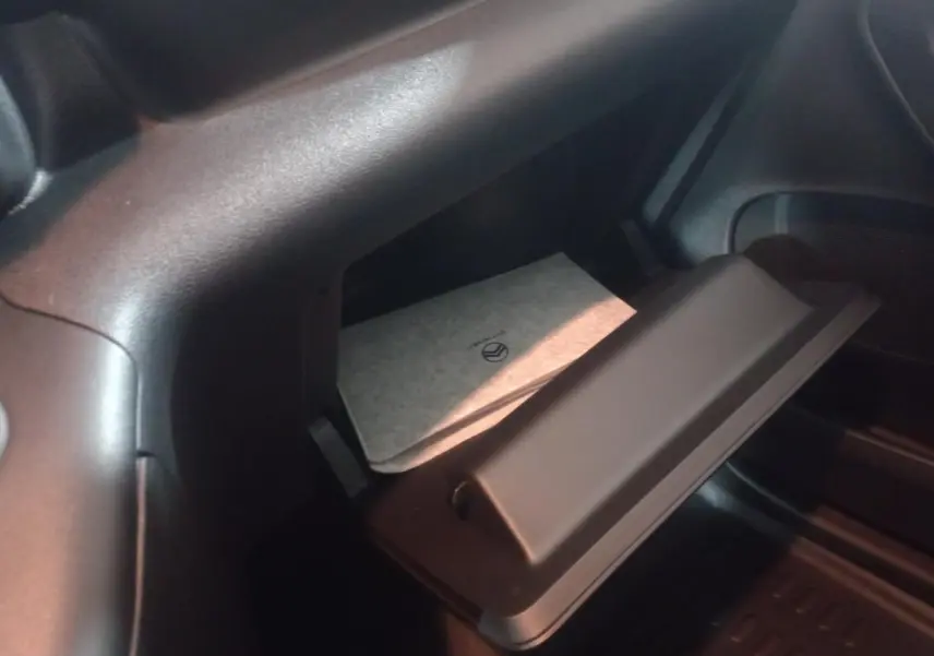 Vue intérieure sur la boîte à gants ouverte du Citroën Berlingo XL blanc 2025 avec manuel visible.