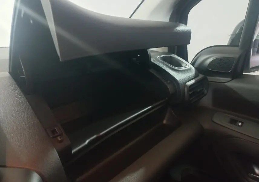 Vue intérieure côté passager du Citroën Berlingo XL blanc 2025, avec boîte à gants ouverte et aérateur visible.