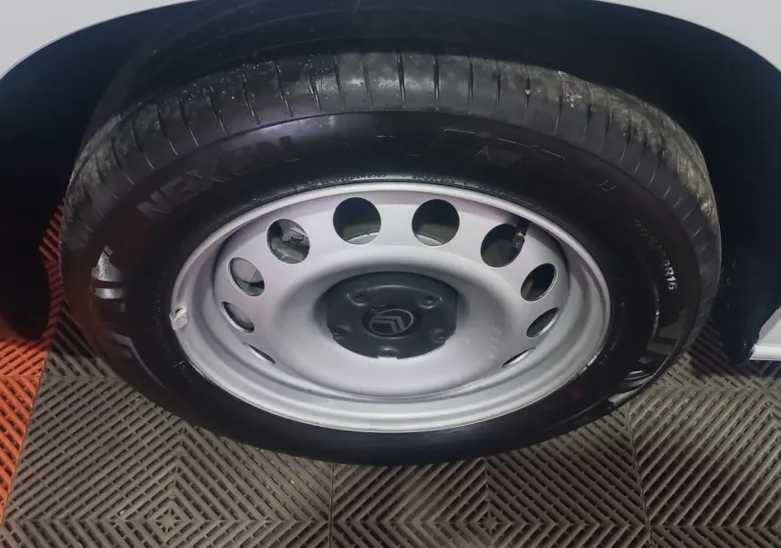 Gros plan sur la roue avant droite avec jante acier grise et logo Citroën sur un véhicule blanc.