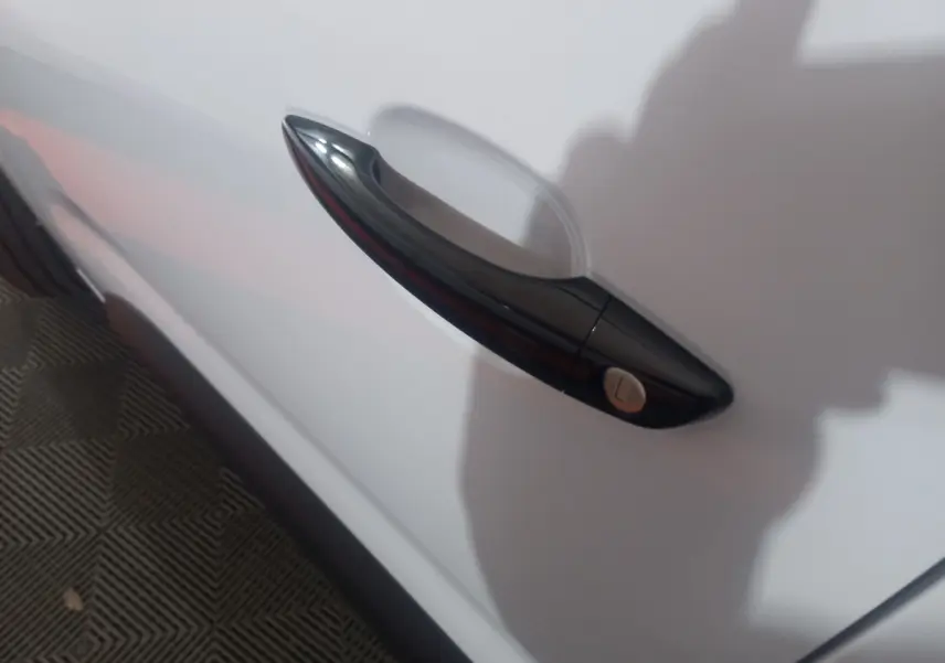 Poignée de porte noire en gros plan sur la porte blanche côté gauche d'un Citroën Berlingo XL 2025.