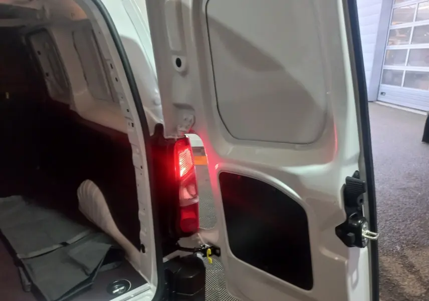 Vue intérieure arrière droite du Citroën Berlingo XL blanc 2025 avec porte ouverte et feu arrière allumé.